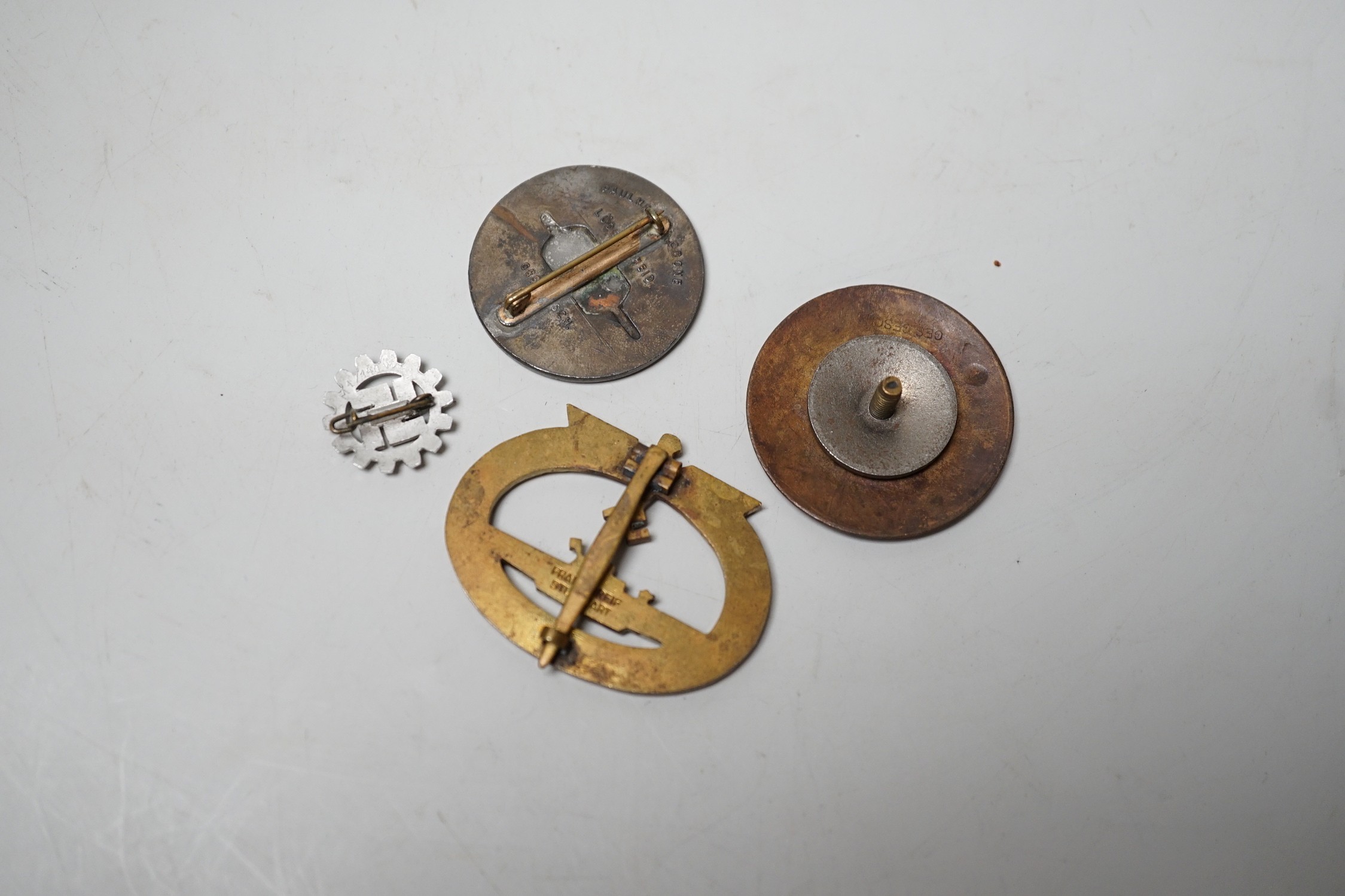 Four German WWII badges including a Kriegsmarine submarine war badge, maker’s mark Frank and Reif Stuttgart